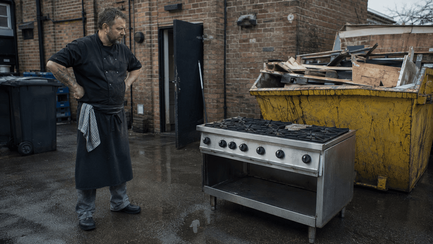 Chef owner photographing a shrink wrapped commercial gas range on a pallet, ready to sell rather than scrap.
