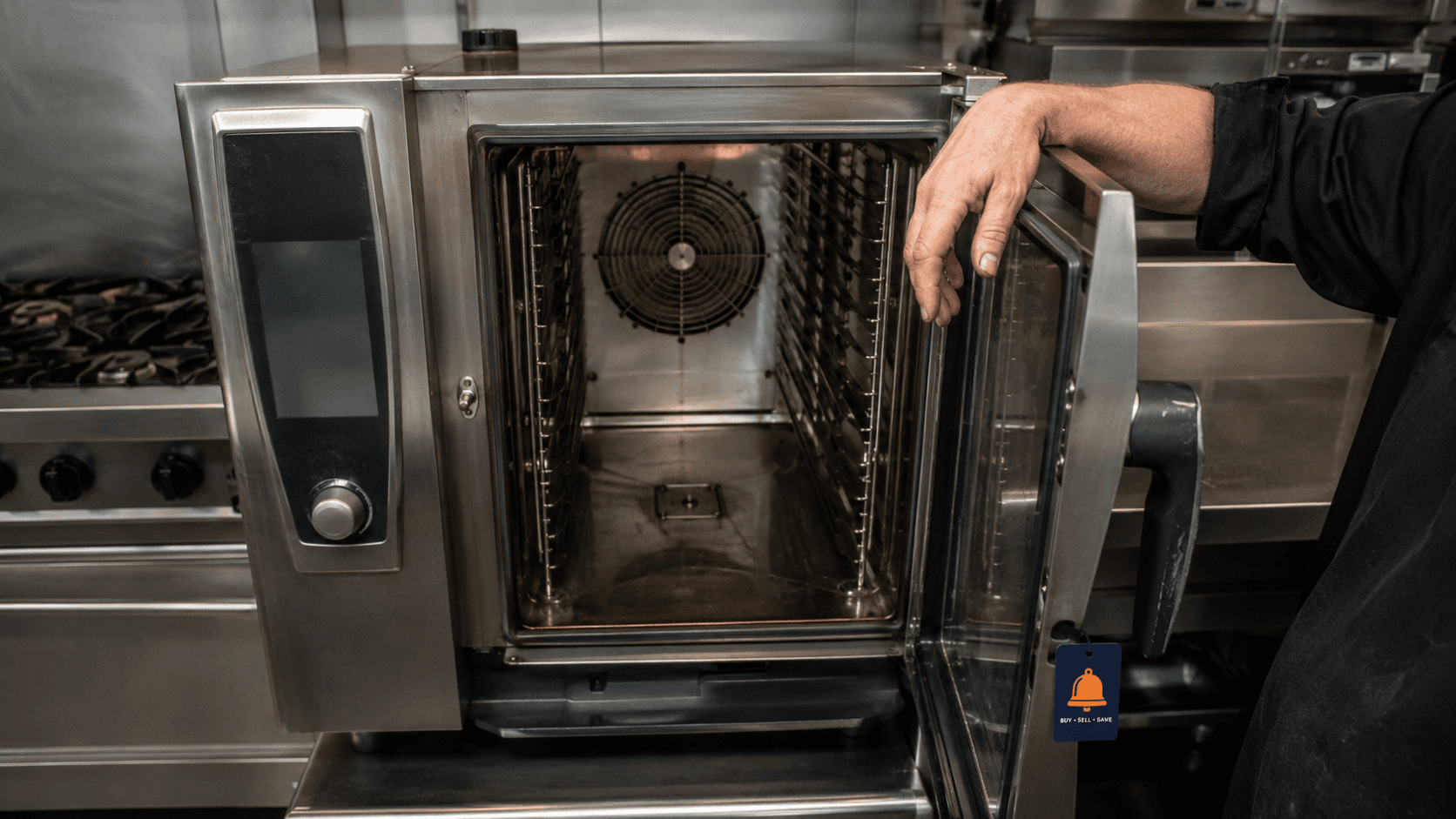 Used commercial combi oven in a UK kitchen with its door open, showing the interior fan and racking runners.
